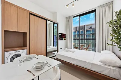 a bedroom with a bed and a large window at Binghatti House JVC - Parking, Balcony, Gym & Pool in Dubai