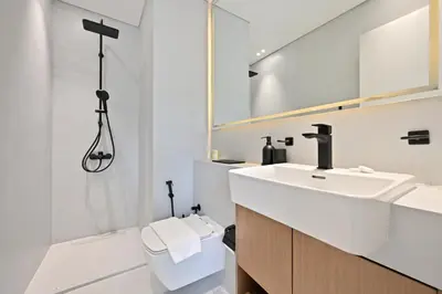 a bathroom with a sink and a toilet and a mirror at Binghatti House JVC - Parking, Balcony, Gym & Pool in Dubai