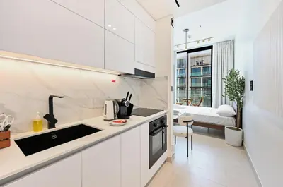 a white kitchen with a sink and a counter at Binghatti House JVC - Parking, Balcony, Gym & Pool in Dubai