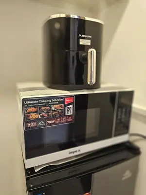 a microwave with a coffee pot on top of it at Elegant Grey Studio Room with Free Parking and Gaming in Dubai