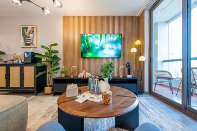 a living room with a table and a tv on a wall at Boutique 3BR in JBR Upgraded by UDH in Dubai