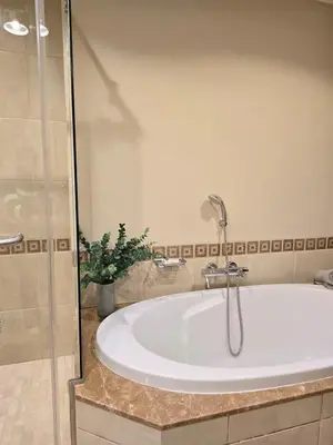 a bath tub in a bathroom with a shower at Fairmont North Residences Palm Jumeirah in Dubai
