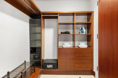 a closet with a wooden cabinet next to a staircase at Renovated 2 Br in Golden Mile 5 Near Nakheel Mall in Dubai