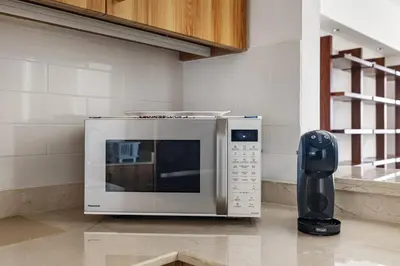 a microwave oven sitting on the floor next to a phone at Renovated 2 Br in Golden Mile 5 Near Nakheel Mall in Dubai