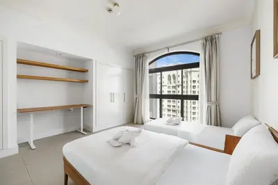 a bedroom with two beds and a large window at Renovated 2 Br in Golden Mile 5 Near Nakheel Mall in Dubai