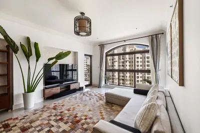 a living room with a couch and a large window at Renovated 2 Br in Golden Mile 5 Near Nakheel Mall in Dubai