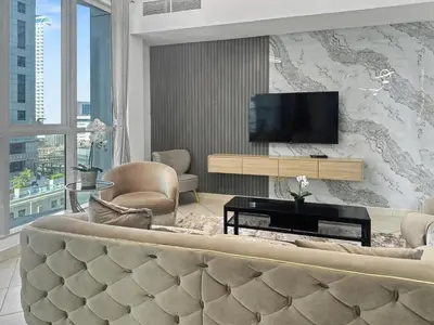 a living room with a couch and a flat screen tv at Cozy 2BR l Marina l Steps to Beach l Balcony l Pool in Dubai