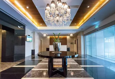 a lobby with a table and a chandelier at Cozy 2BR l Marina l Steps to Beach l Balcony l Pool in Dubai