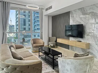 a living room with a couch and a tv at Cozy 2BR l Marina l Steps to Beach l Balcony l Pool in Dubai