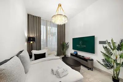 a hotel room with a bed and a chandelier at FIRST CLASS 1BR Luxury Comfort Prime Location in Dubai