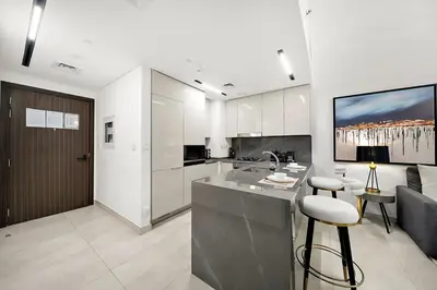 a kitchen with a counter and a bar with a stool at FIRST CLASS 1BR Luxury Comfort Prime Location in Dubai