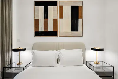 a bedroom with a white bed with two side tables at FIRST CLASS 1BR Luxury Comfort Prime Location in Dubai
