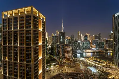 a city skyline at night with a tall building at FIRST CLASS Studio Relaxing Canal View in Dubai