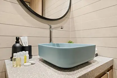 a bathroom with a blue bowl sink and a mirror at FIRST CLASS Studio Relaxing Canal View in Dubai