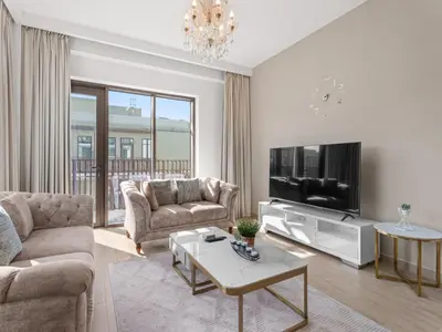 a living room with a couch and a tv at The Royal Suite 1 BDR in Sunset-02 in Dubai