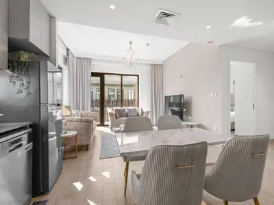 a kitchen and living room with a table and chairs at The Royal Suite 1 BDR in Sunset-02 in Dubai