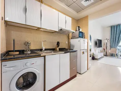 a kitchen with a washing machine and a refrigerator at Modern Comfort City Studio In Al Manara 04 in Dubai