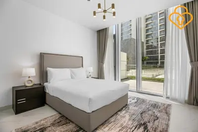 a bedroom with a bed and a large window at Beautiful Large 1BR Apt in District 1, MBR Minutes to Downtown in Dubai