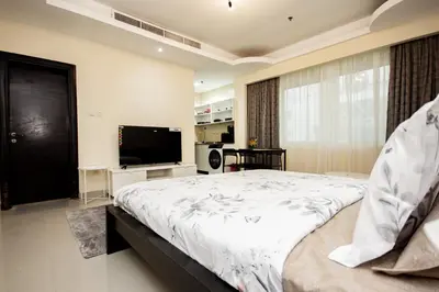 a bedroom with a large bed and a flat screen tv at Fully Furnished Studio at City Tower al Barsha Near Mall of the Emirates in Dubai