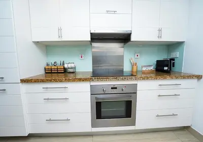 a kitchen with white cabinets and a stove at Luxury Executive 1BR with Full Burj Khalifa View- Downtown in Dubai
