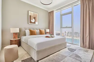 a bedroom with a large bed and a large window at Frank Porter - Palace Beach Residence in Dubai
