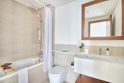 a bathroom with a tub and a toilet and a sink at Frank Porter - Palace Beach Residence in Dubai