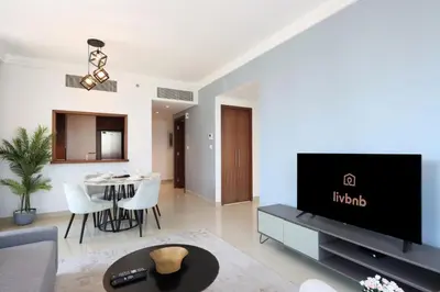 a living room with a tv and a table at Spacious 1BR with Open Views Boulevard Point Near Dubai Mall in Dubai