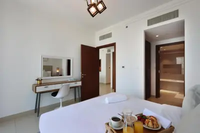 a hotel room with a bed with a tray of food on it at Spacious 1BR with Open Views Boulevard Point Near Dubai Mall in Dubai