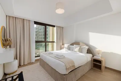 a bedroom with a large bed and a large window at Al Jazi 2, Madinat Jumeirah Living - Mint Stay in Dubai