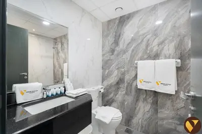 a bathroom with a toilet and a sink and a mirror at Vogue Elite Business Bay Residence Close to Burj Khalifa and Dubai Mall, Studio Apartment with Balcony, City and Canal View, Access to all Amenities in Dubai