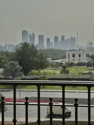 a car driving down a street with a city in the background at Elegant 1BR with Skyline View Bright & Modern by Crescent Key in Dubai