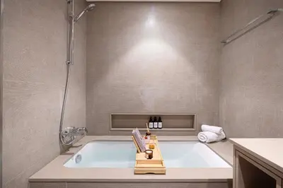 a bathroom with a tub with a shower and a sink at INCREDIBLE BURJ KHALIFA & DUBAI FOUNTAIN Views - 2 BR Luxury Apartment - Sanctuary Stays in Dubai