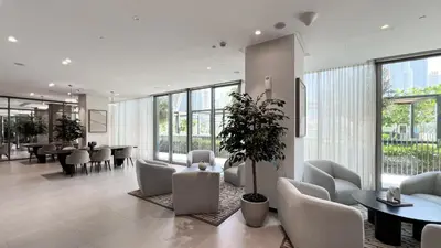 a lobby with white chairs and tables and windows at INCREDIBLE BURJ KHALIFA & DUBAI FOUNTAIN Views - 2 BR Luxury Apartment - Sanctuary Stays in Dubai