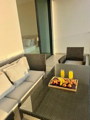 a table with a tray of fruit and two glasses of orange juice at Elegant Dubai Stay Pool, Gym, Padel & Concierge in Dubai