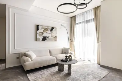 a living room with a white couch and a table at LUX 2 BDR apartment - Burj Khalifa view in Dubai