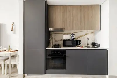 a kitchen with a stove and a microwave at Chic Studio with Balcony & Pool in Oxford Gardens in Dubai