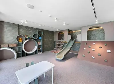 a childrens playroom with a slide and a climbing wall at Chic Studio with Balcony & Pool in Oxford Gardens in Dubai