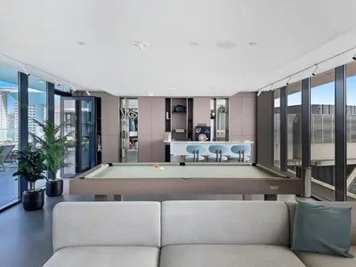 a living room with a couch and a swimming pool at Chic Studio with Balcony & Pool in Oxford Gardens in Dubai