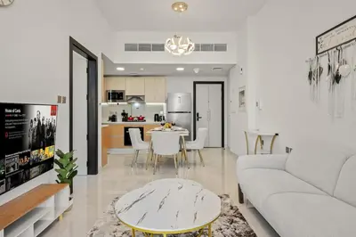 a living room with a couch and a table at FIRST CLASS 1BR Miracle Garden View Skyz Arjan in Dubai