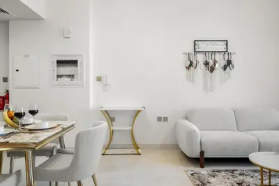 a living room with a couch and a table at FIRST CLASS 1BR Miracle Garden View Skyz Arjan in Dubai