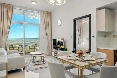 a kitchen and living room with a table and chairs at FIRST CLASS 1BR Miracle Garden View Skyz Arjan in Dubai