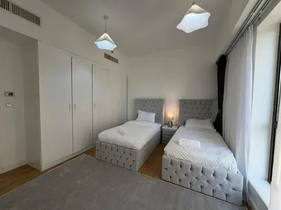 a bedroom with two beds and a couch at 2BR Apartment in JBR The Walk in Dubai