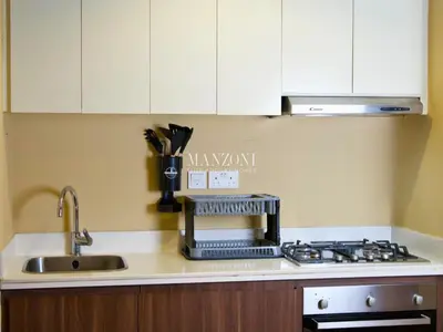 a kitchen counter with a sink and a stove at Business Bay Luxury Apt - 5min Burj Khalifa, Mall & Metro in Dubai