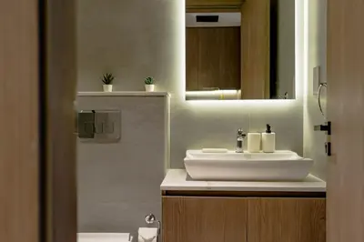 a bathroom with a white sink and a mirror at Nasma Luxury Stays - Contemporary Calm Living Space with upscale Facilities in Dubai