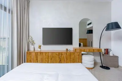 a bedroom with a bed and a television on a dresser at Nasma Luxury Stays - Contemporary Calm Living Space with upscale Facilities in Dubai