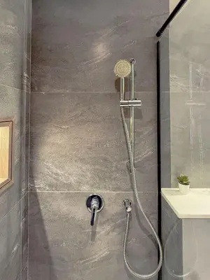 a shower with a shower head in a bathroom at Nasma Luxury Stays - Contemporary Calm Living Space with upscale Facilities in Dubai
