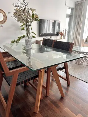 a glass dining table with chairs and a vase with flowers at Premium Downtown 1BD Apartment Burj Khalifa View 9 Mins walk Dubai Mall in Dubai