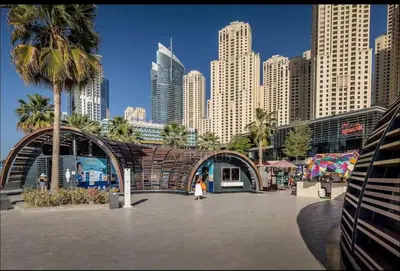 a woman walking in a plaza in front of a city at Sea View Spacious Apartment in JBR in Dubai