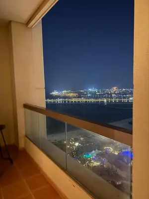 a balcony with a view of a pier at night at Sea View Spacious Apartment in JBR in Dubai