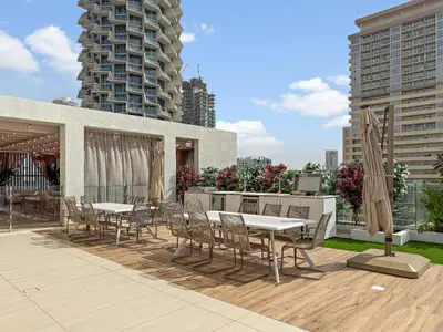 a patio with tables and chairs and some buildings at VayK - Luxury Living with Top Amenities 1BD in JVC in Dubai